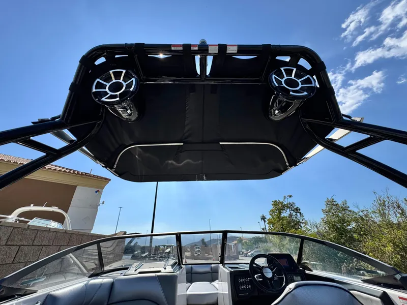 Slide: The Image of 2021 Moomba Craz boat interior with speakers and canopy under a clear blue sky. - 11