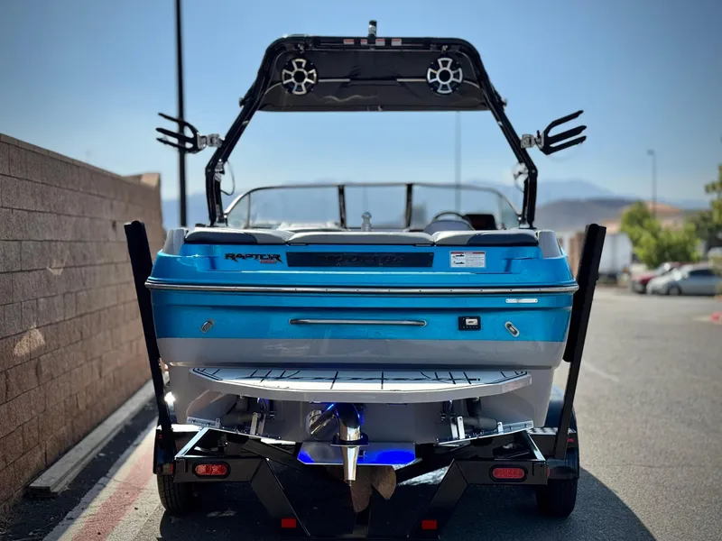 Slide: The Image of 2021 Moomba Craz boat, blue, rear view, parked on street, showcasing wakeboard tower. - 4