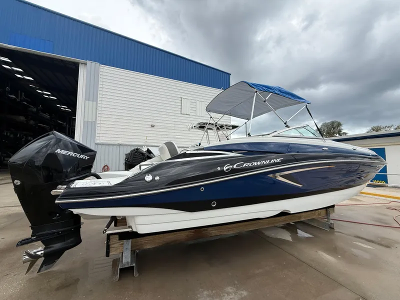Slide: The Image of 2019 Crownline Eclipse E255 XS boat with Mercury engine, docked outdoors. - 12