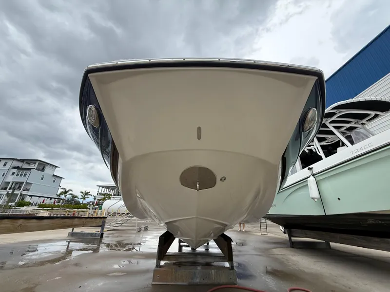 Slide: The Image of 2019 Crownline Eclipse E255 XS boat on dry dock, viewed from the front under cloudy skies. - 20