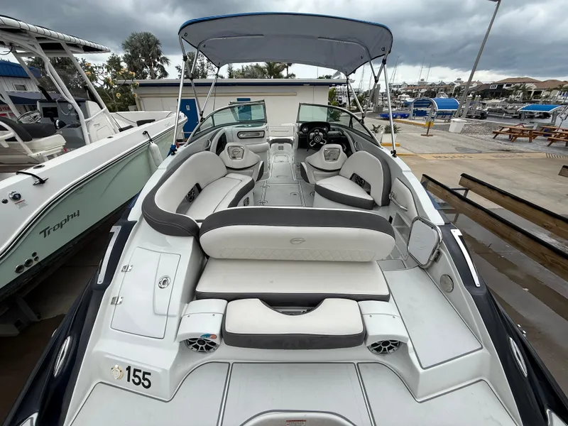 Slide: The Image of 2019 Crownline Eclipse E255 XS boat with spacious seating and canopy in a marina setting. - 21