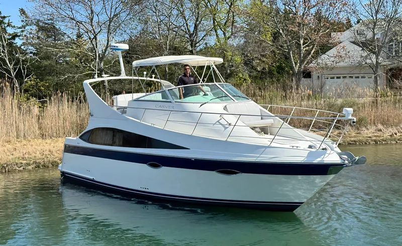 Slide: The Image of 2008 Carver 36 Mariner yacht cruising on a serene waterway. - 0