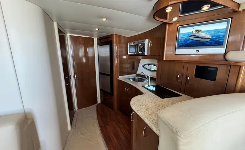 Slide: The Image of 2008 Carver 36 Mariner yacht interior with kitchen, microwave, and TV. - 13