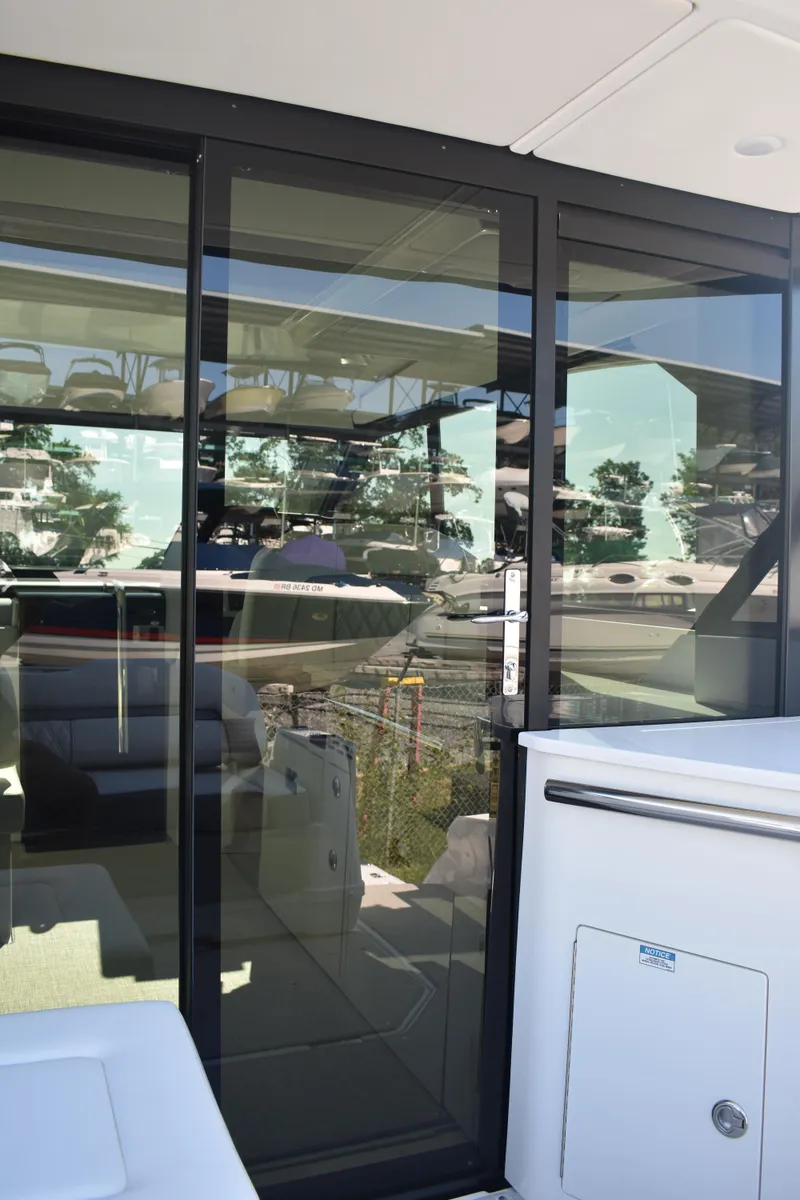 Slide: The Image of 2023 Regal 36 XO yacht with sleek glass doors and modern interior design. - 24