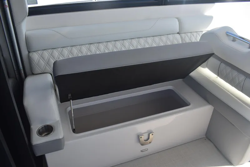 Slide: The Image of 2023 Regal 36 XO boat interior with open storage compartment and cup holder. - 36