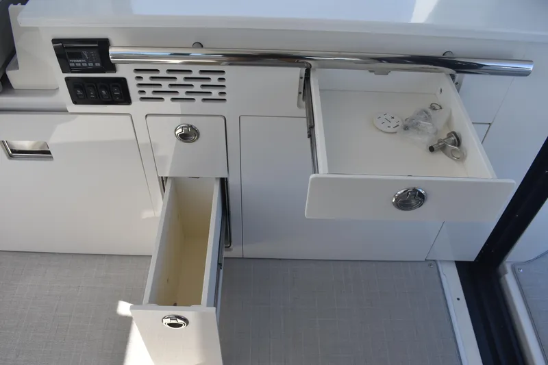 Slide: The Image of 2023 Regal 36 XO yacht interior with open storage drawers and control panel. - 48