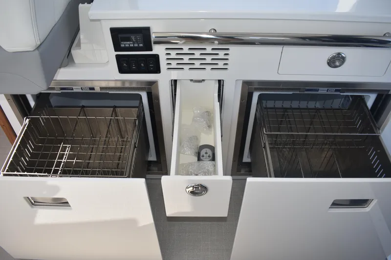 Slide: The Image of 2023 Regal 36 XO yacht interior with open storage compartments and control panel. - 49