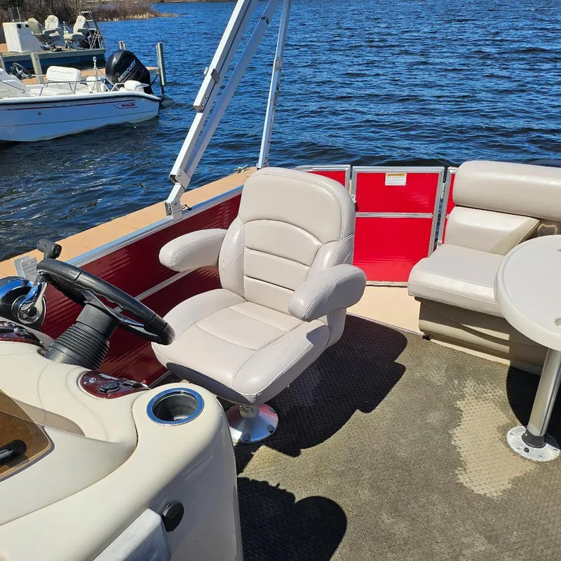 Slide: The Image of 2018 Starcraft EX 18 C pontoon boat interior with beige seating and steering wheel. - 4