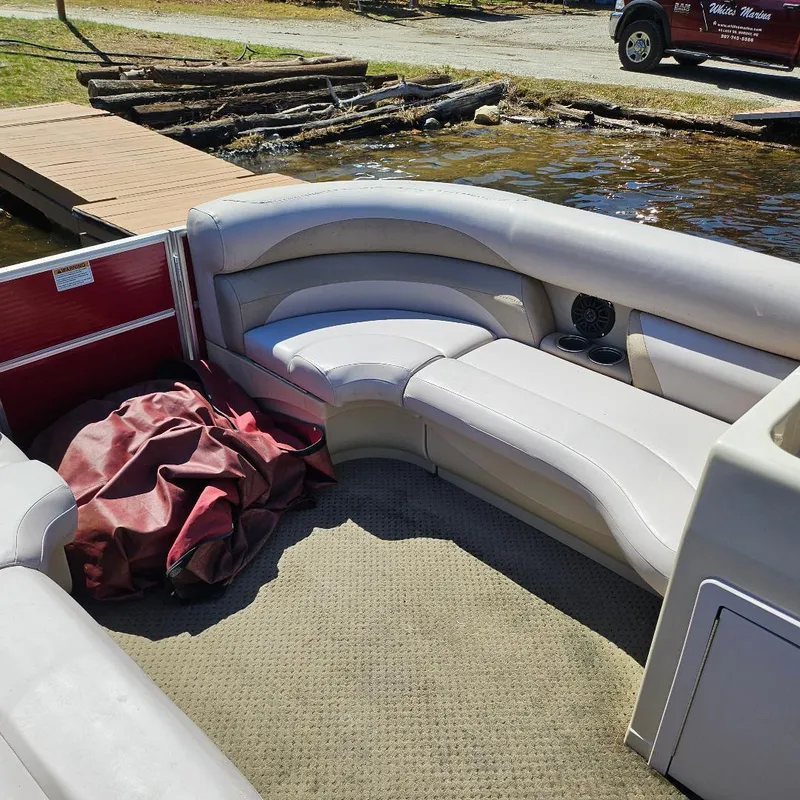 Slide: The Image of 2018 Starcraft EX 18 C pontoon boat interior with beige seating and red cover. - 5