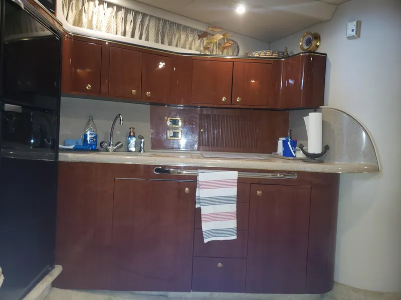 Slide: The Image of 2001 Sea Ray 410 Sundancer kitchen with wooden cabinets and modern amenities. - 18
