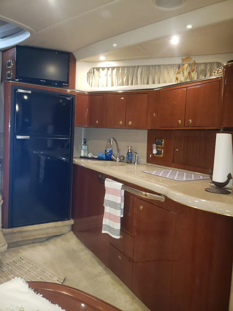 Slide: The Image of Interior of 2001 Sea Ray 410 Sundancer yacht with modern kitchen amenities. - 19