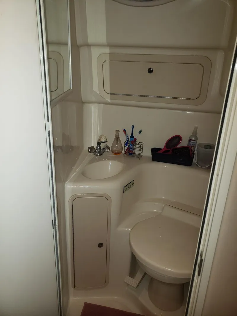 Slide: The Image of Compact bathroom in 2001 Sea Ray 410 Sundancer yacht, featuring sink and toilet. - 23