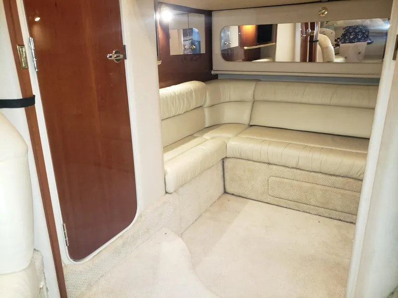 Slide: The Image of Interior of 2001 Sea Ray 410 Sundancer with beige leather seating and wooden accents. - 25