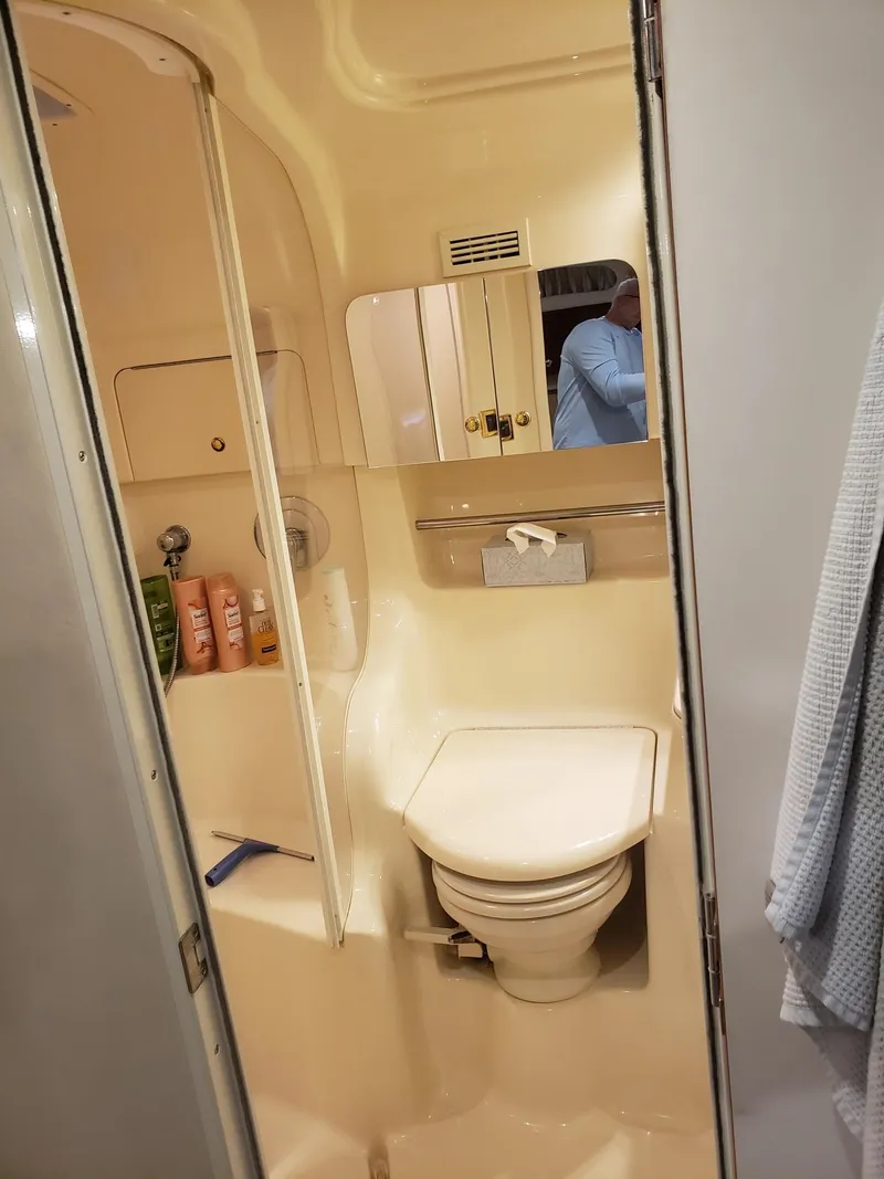 Slide: The Image of 2001 Sea Ray 410 Sundancer bathroom with toilet, mirror, and toiletries. - 27