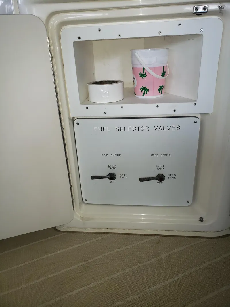 Slide: The Image of Fuel selector valves on 2001 Sea Ray 410 Sundancer boat, with storage shelf above. - 29