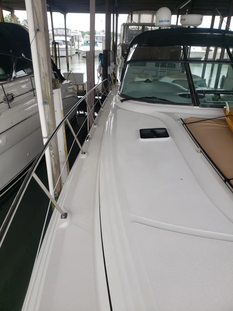 Slide: The Image of 2001 Sea Ray 410 Sundancer docked in a marina, showcasing sleek design and spacious deck. - 4