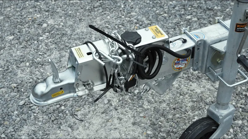 Slide: The Image of Trailer hitch of a 2025 Tahoe Pontoon Aura 2185 Quad Lounger Triple on gravel. - 20