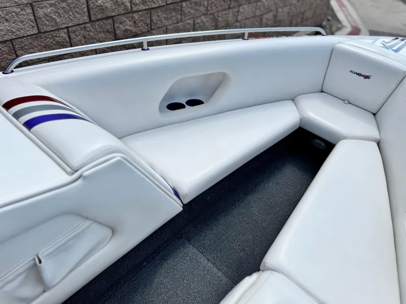 Slide: The Image of 2005 Eliminator Eagle 230 XP boat interior with white seating and striped accents. - 11
