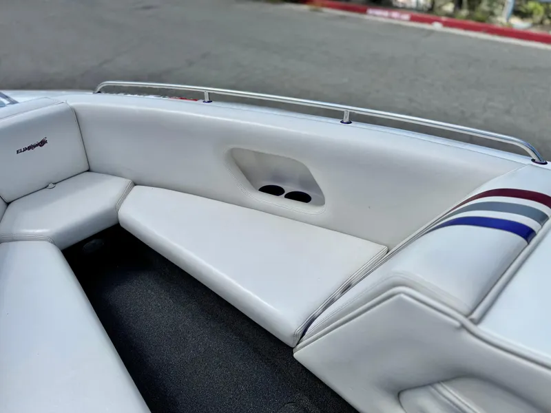 Slide: The Image of Interior of a 2005 Eliminator Eagle 230 XP boat with white seating and striped accents. - 12