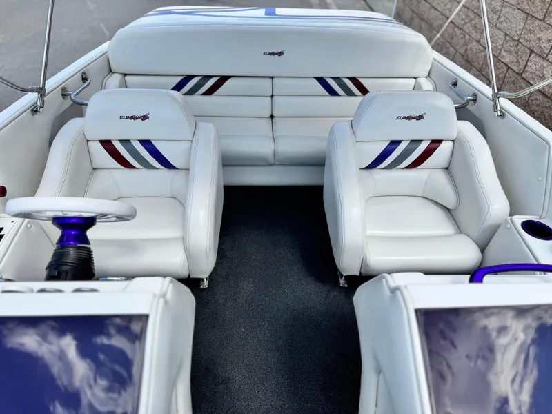 Slide: The Image of 2005 Eliminator Eagle 230 XP boat interior with white seating and striped accents. - 13