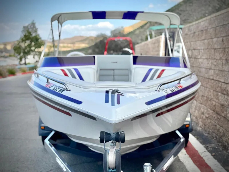 Slide: The Image of 2005 Eliminator Eagle 230 XP boat with colorful interior, parked on a trailer. - 2