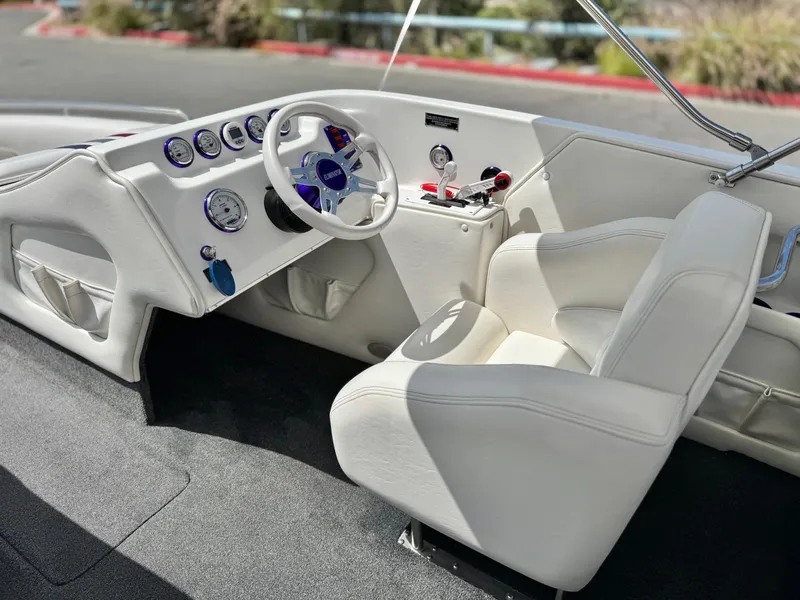 Slide: The Image of 2005 Eliminator Eagle 230 XP boat interior with white seating and dashboard controls. - 20