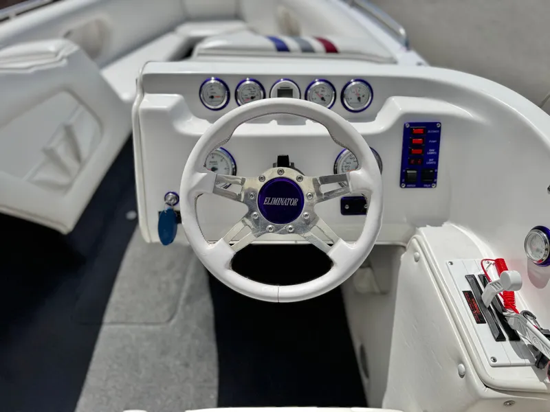 Slide: The Image of 2005 Eliminator Eagle 230 XP boat dashboard with steering wheel and gauges. - 21
