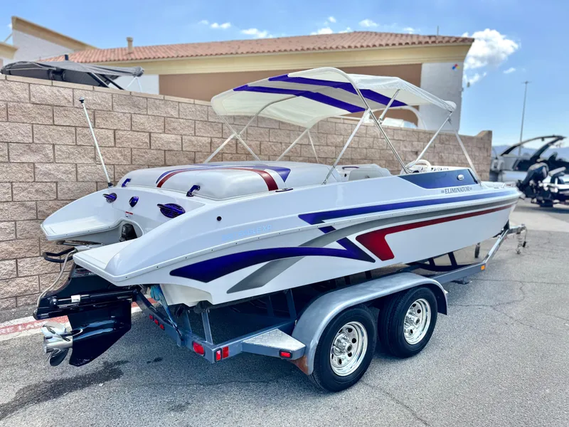 Slide: The Image of 2005 Eliminator Eagle 230 XP boat on trailer with canopy, parked outdoors. - 5