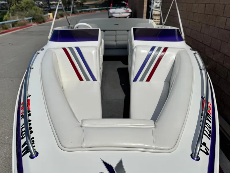 Slide: The Image of 2005 Eliminator Eagle 230 XP boat with white and striped interior design. - 9