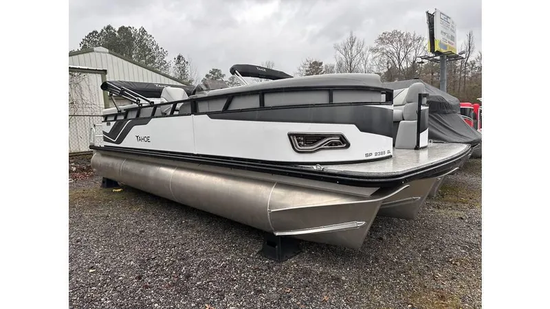 Slide: The Image of 2025 Tahoe Pontoon Sport 85 Quad Lounger, sleek design, parked outdoors on gravel. - 7