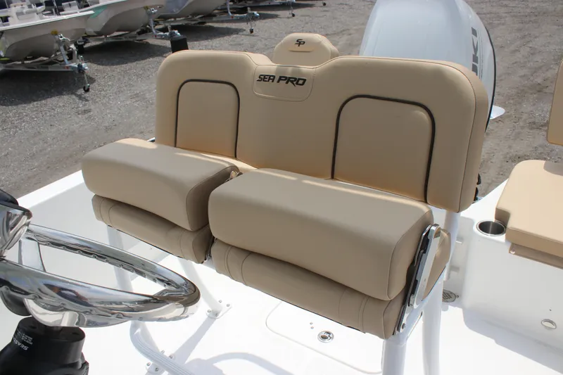 Slide: The Image of 2025 Sea Pro 202 CC boat seating with beige cushions and steering wheel. - 23