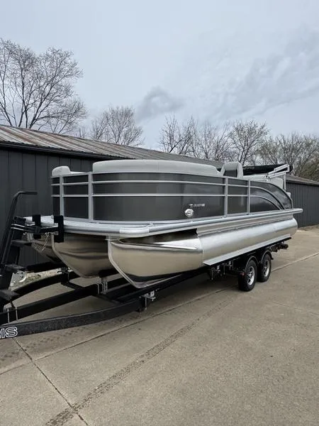 Slide: The Image of 2025 Harris Cruiser 210 pontoon boat on trailer, parked outdoors. - 0