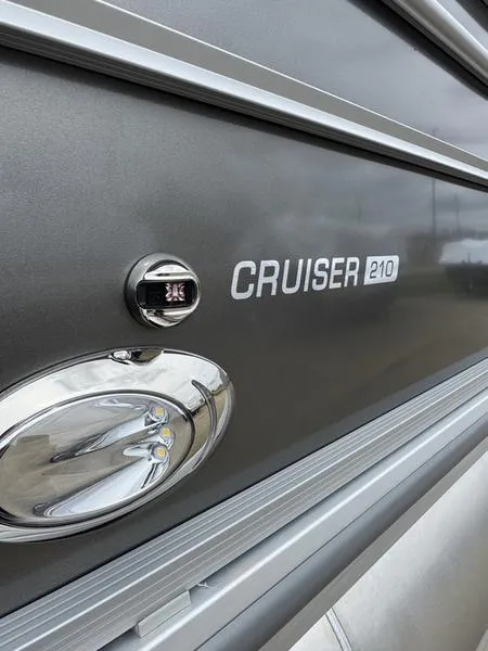 Slide: The Image of 2025 Harris Cruiser 210 boat exterior with sleek metallic finish and logo detail. - 3