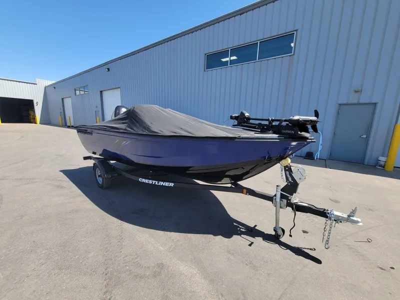 Slide: The Image of 2023 Crestliner 1750 Fish Hawk SE SC boat on trailer, covered, outside industrial building. - 13
