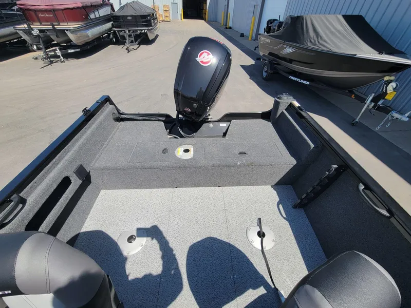 Slide: The Image of 2023 Crestliner 1750 Fish Hawk SE SC boat interior with motor, parked outdoors. - 15