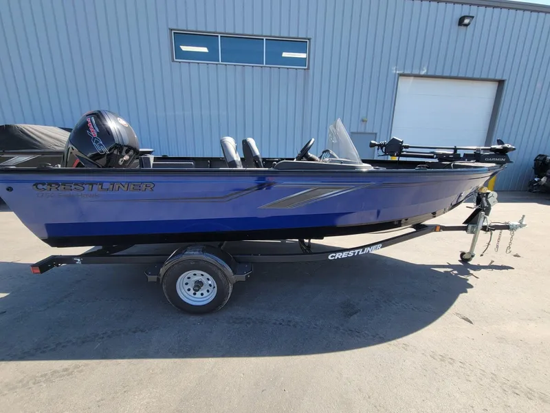 Slide: The Image of 2023 Crestliner 1750 Fish Hawk SE SC boat on trailer, parked outside a building. - 5