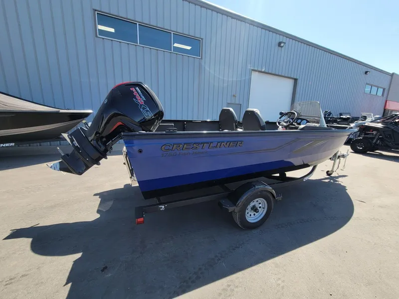 Slide: The Image of 2023 Crestliner 1750 Fish Hawk SE SC boat with outboard motor, parked outside a warehouse. - 6