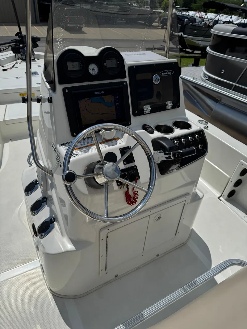 Slide: The Image of 2017 NauticStar 2200 Sport boat console with steering wheel and navigation controls. - 6