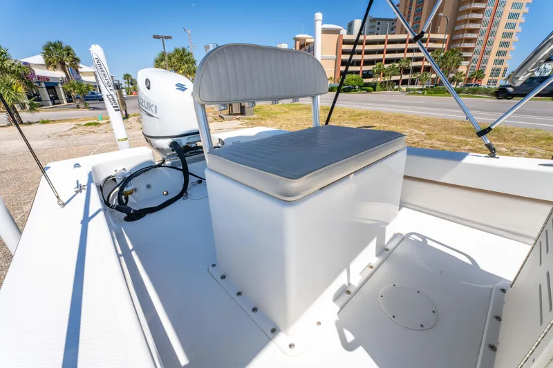 Slide: The Image of 2016 Panga 19 Niente boat interior with seating and motor, parked near buildings. - 12