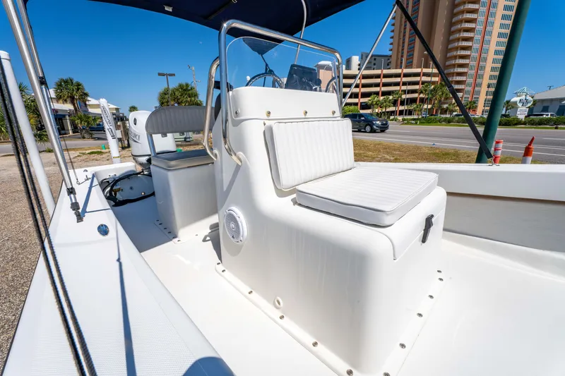 Slide: The Image of 2016 Panga 19 Niente boat with white seating and console, parked near a road. - 13