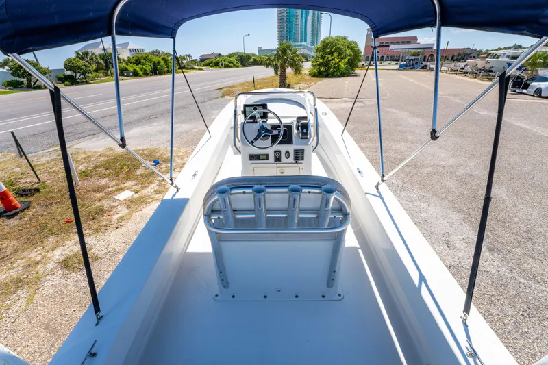 Slide: The Image of 2016 Panga 19 Niente boat with canopy, parked on roadside, showcasing steering console. - 17