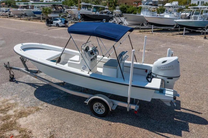 Slide: The Image of 2016 Panga 19 Niente boat on trailer with blue canopy, parked in a marina. - 2