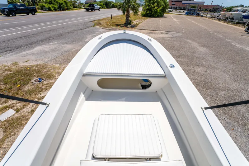 Slide: The Image of 2016 Panga 19 Niente boat interior with white seating, parked near a road. - 22