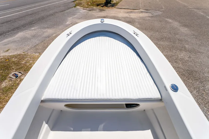 Slide: The Image of 2016 Panga 19 Niente boat bow with white cushioned seating, parked on pavement. - 23