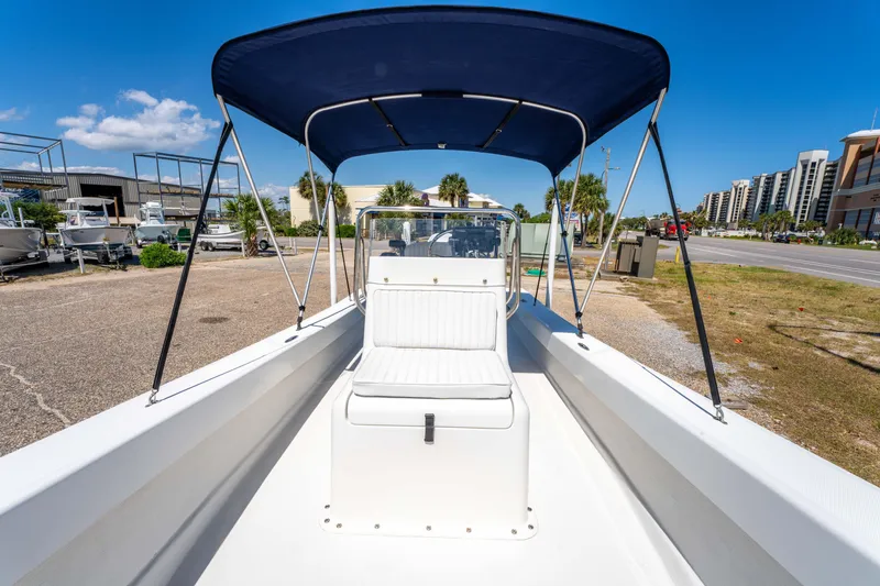 Slide: The Image of 2016 Panga 19 Niente boat with blue canopy, docked under clear sky. - 24
