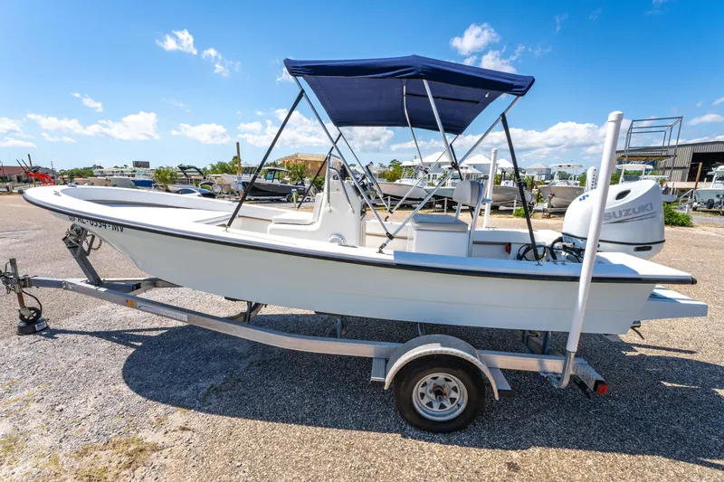 Slide: The Image of 2016 Panga 19 Niente boat on trailer with blue canopy, parked outdoors under clear sky. - 7