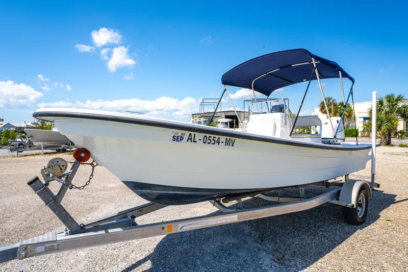 Slide: The Image of 2016 Panga 19 Niente boat on trailer with blue canopy, parked outdoors. - 8