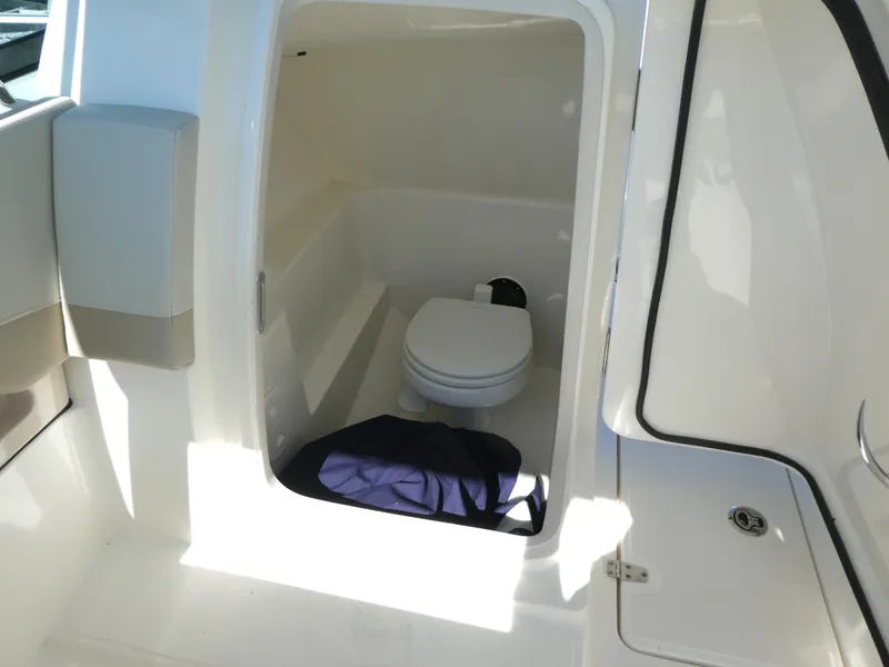 Slide: The Image of 2022 Boston Whaler 240 Vantage boat interior with compact marine toilet. - 13