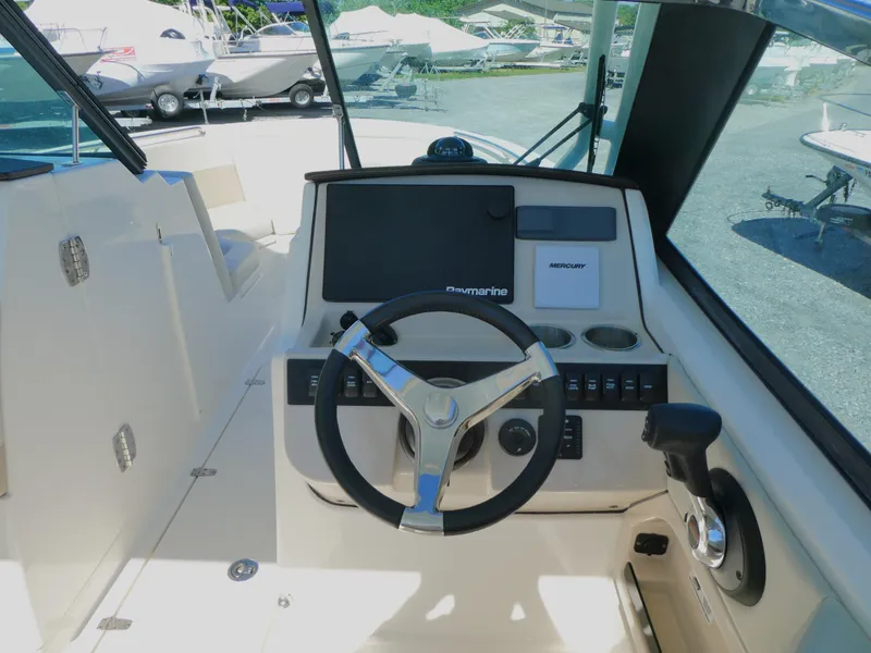 Slide: The Image of 2022 Boston Whaler 240 Vantage boat cockpit with steering wheel and control panel. - 4
