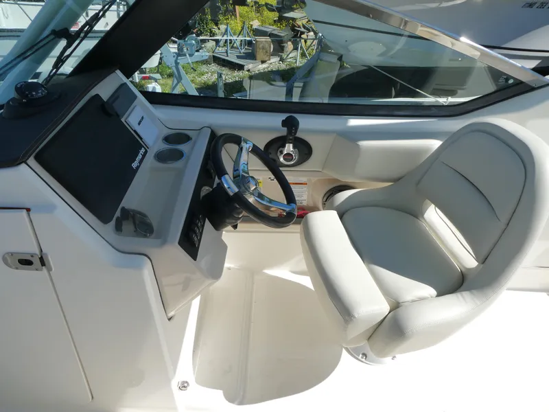 Slide: The Image of 2022 Boston Whaler 240 Vantage helm with steering wheel and comfortable captain's chair. - 5